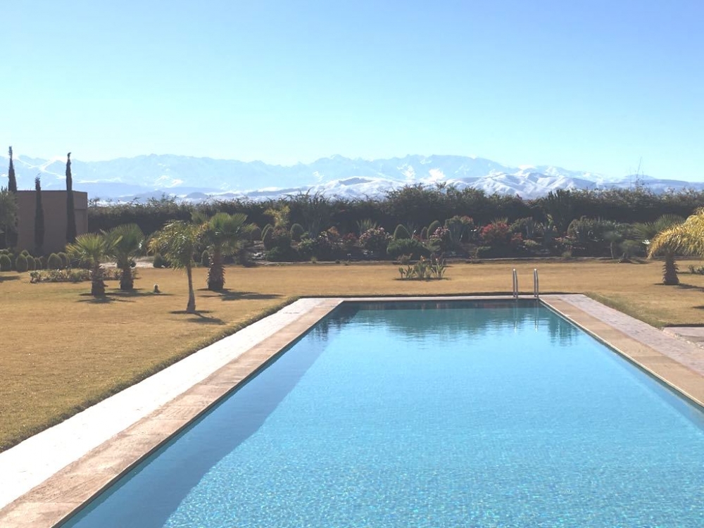 klm  18 km route d’Amizmiz à 20 mins du centre ville et à moins de 10 mins des principaux golf de Marrakech, superbe  villa contemporaine , 5 chambres dont 3 suites + 2 chambres pour le personnel  , 551 m2 habitable sur 2 niveaux le tout bâtie sur un superbe parc arboré planté de 10 000 m2  comprenant un verger et une superbe piscine à débordement de 25 x 6 m.