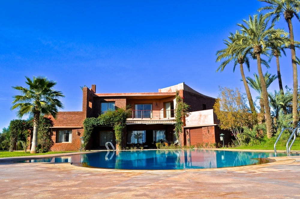BAB ATLAS  au sein du secteur le plus recherché de la palmeraie à 15 mins du centre-ville de Marrakech , superbe villa de maitre empreinte de modernité  750 m2 de surface utile sur 2 niveaux  bâtie sur un parc de 20 000  m2 , 5 suites dont une master suite, 1 grande piscine extérieure,  1 sauna avec salle de repos, 2 chambres du personnel et un espace parking pour 5 voitures et 2 garages fermés, finitions haut de gamme et matériaux nobles + 1 pavillon indépendant de style Riad de 100 m2 habitable  doté d’1 salon marocain, 1cuisine américaine ouverte sur un salon cheminée,1 véranda, 1 chambre à coucher et SDB avec baignoire une entrée indépendante avec 1 garage sous véranda pour 3 voitures.